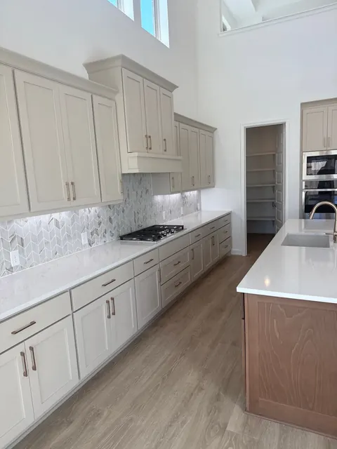 Cocina con gabinetes estilo shaker, salpicadero en espiga y estufa de gas