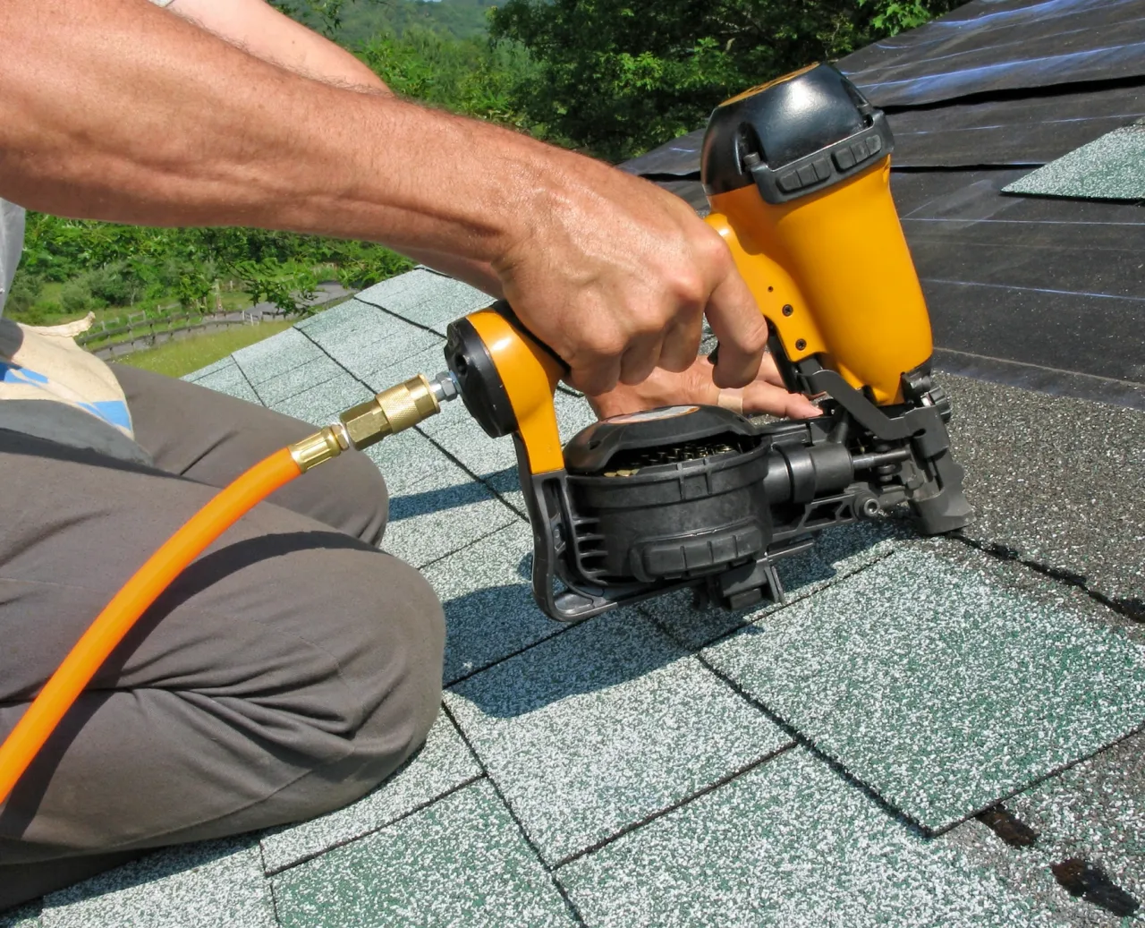 A roofing nailer fastening asphalt shingles